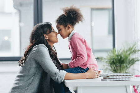 african american mother able to kiss her little daughterの写真素材