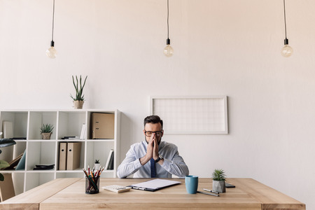 bearded businessman sitting at table in modern officeの写真素材