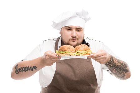 cooker looking at burgers on plate isolated on white