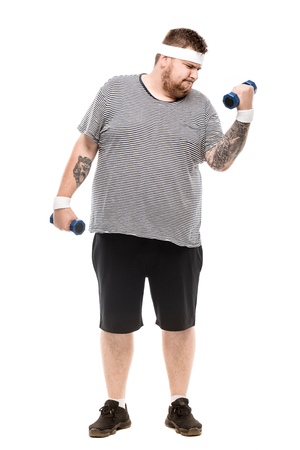 fat man exercising with dumbbells isolated on whiteの写真素材
