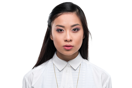 beautiful serious asian girl in white blouse looking at camera,の写真素材