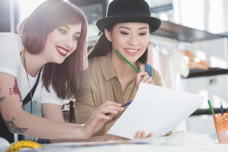 young fashion designers looking at sketch and discussingの写真素材