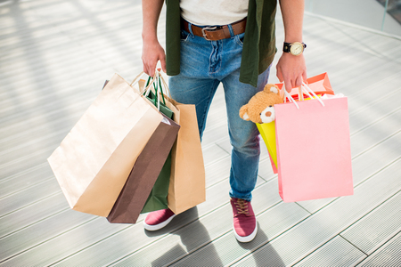 cropped shot of man standing and holding shopping bags in handsの写真素材