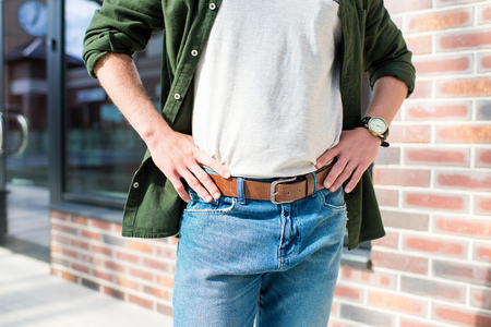 cropped shot of man in casual clothing standing with hands on hips on streetの写真素材