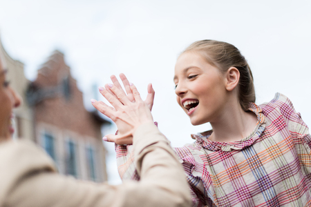 emotional daughter giving high five to her motherの写真素材
