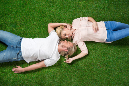 young sweethearts relaxing together and lying on the grassの写真素材