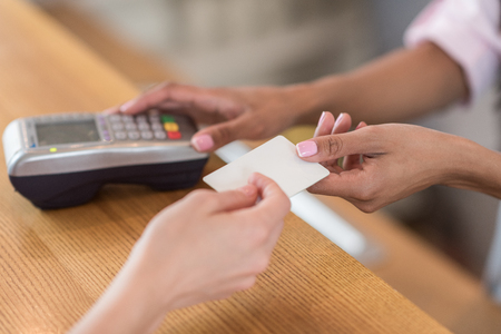 woman giving credit card to waitress for payment in cafeの写真素材