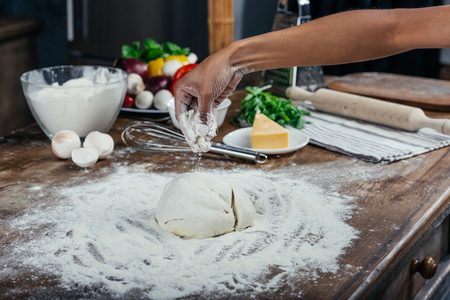 woman preparing pizza dough in kitchenの写真素材