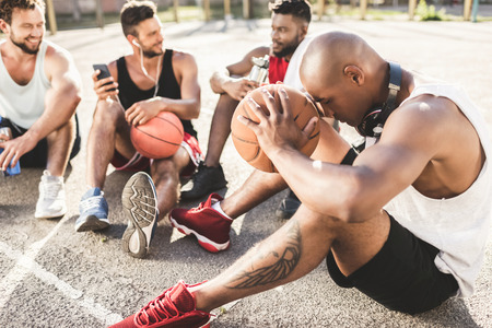 basketball team sitting after game on basketball court together