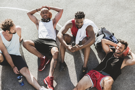 basketball team sitting after game on basketball court togetherの写真素材