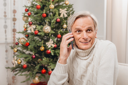 man talking by phone on christmasの写真素材