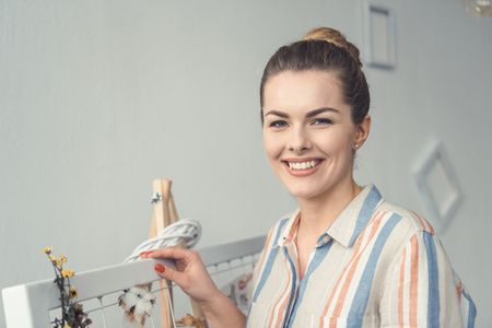 attractive female florist standing at board at workplaceの写真素材