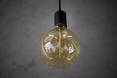 big vintage light bulb hanging from grey ceiling