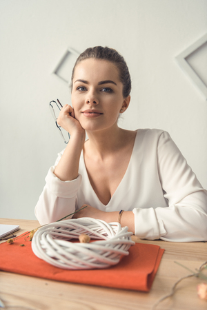 beautiful female decorator with white wreath at workplaceの写真素材