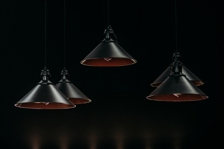 vintage black lamps hanging in dark interiorの写真素材