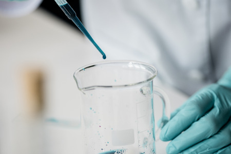 scientist working with pipette and reagent while making experiment in labの写真素材