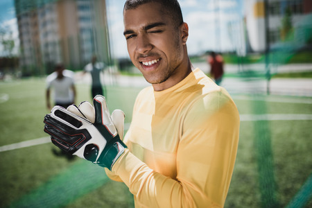 african american goalkeeper in soccer gloves on pitch