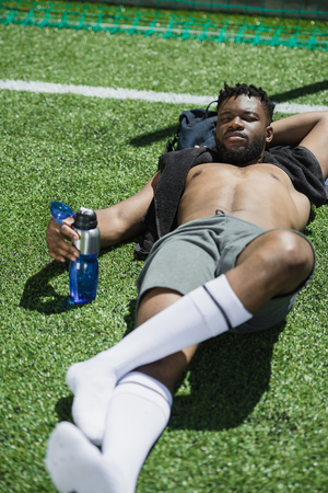 american soccer player resting on soccer pitch after gameの写真素材