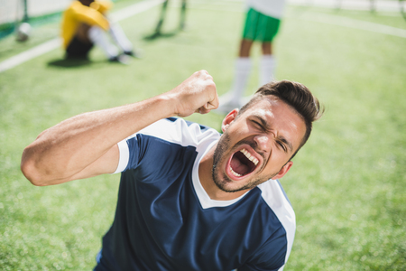 happy soccer player celebrating goal during soccer matchの写真素材