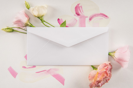 white envelope, beautiful pink flowers and watercolor strokes on grey