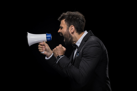 handsome bearded angry businessman yelling in megaphoneの写真素材