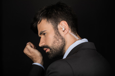 Secret service agent in suit using earphone