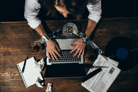 young man with tied hands using laptop with blank screenの写真素材