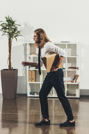 handsome young businessman holding folders and running in officeの写真素材