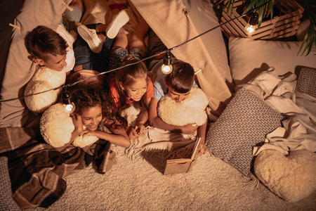multicultural group of children reading book togetherの写真素材