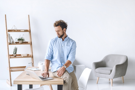 businessman sitting on table and working on laptop in officeの写真素材