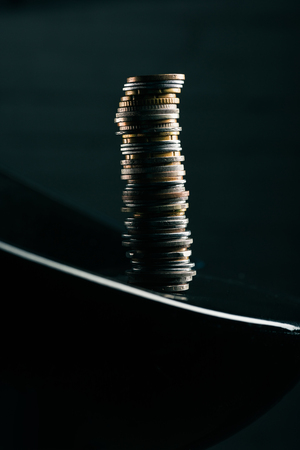 stack of different coins standing on edge of tableの写真素材