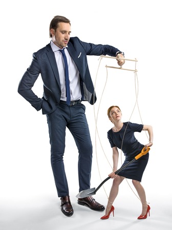 businesswoman with shovel in hands manipulated by bossの写真素材