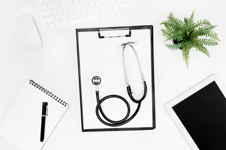 flat lay with stethoscope, clipboard, empty notebook and digital devicesの写真素材