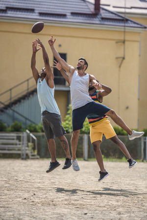 young multicultural men playing football on courtの写真素材