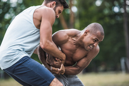 young multicultural men playing football on courtの写真素材