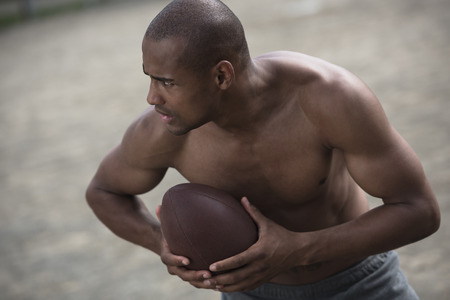 handsome african american male football player with ballの写真素材