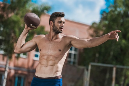 handsome male football player with ball on courtの写真素材