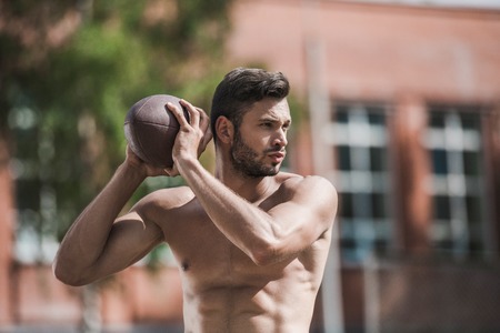 handsome male football player with ball on courtの写真素材