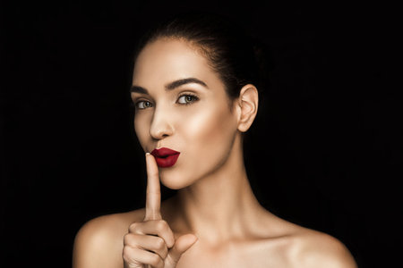beautiful seductive woman with shh symbolの写真素材