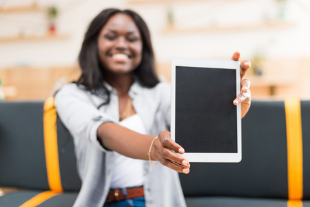 african american woman presenting digital tablet with blank screen
