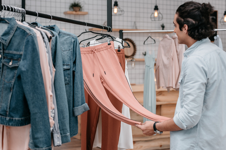 young man selecting clothes before opening in boutiqueの写真素材