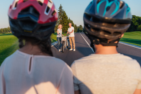 children looking at grandparents with bicycleの写真素材