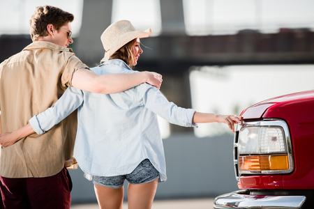 young couple walking near carの写真素材