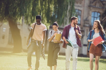 multicultural students walking in parkの写真素材