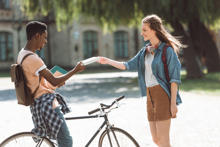 multiethnic couple with books and bicycleの写真素材