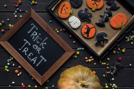 top view of beautiful halloween composition with cookies, chalkboard and pumpkinの写真素材