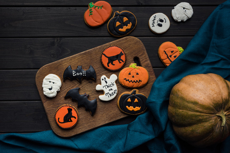 composition of halloween cookies on wooden board and blue clothの写真素材