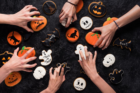 top view of group of people with halloween cookiesの写真素材