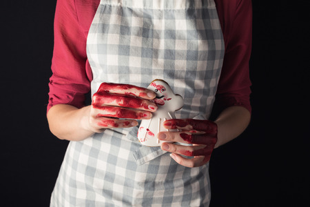cropped shot of girl with bloody hands holding halloween cookie in shape of ghostの写真素材
