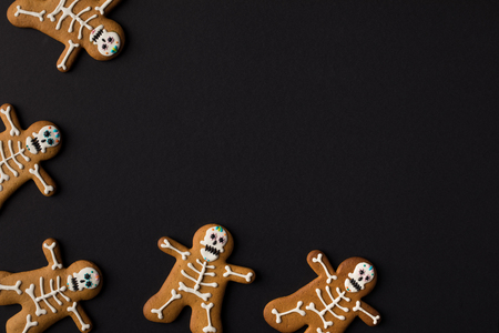 top view of halloween cookies in shape of skeletons isolated on blackの写真素材